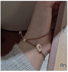 Gros plan d'un pendentif pomme en argent S925 sur un bracelet en corde tressée