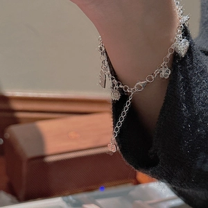 S925 sterling silver charm bracelet featuring heart, star and flower pendants on wrist