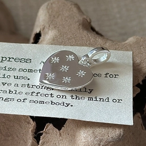 Polished S925 sterling silver heart pendant with starburst engravings on vintage card