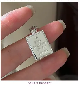 Detail of S925 sterling silver rectangular pendant with engraved quote and small zircon