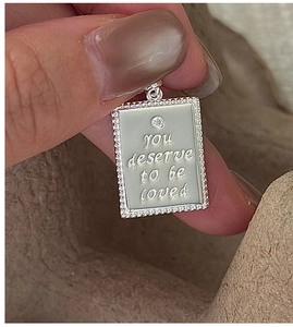 Close-up of S925 sterling silver square pendant with you deserve to be loved engraving
