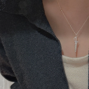 Detail of vintage silver umbrella pendant with small crystals on a delicate beaded chain