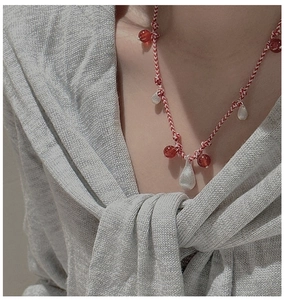 Close-up of S925 silver necklace with red woven cord and silver teardrop pendants