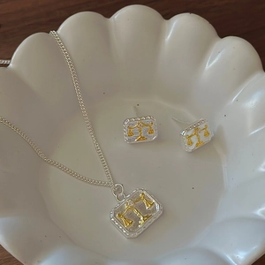 S925 sterling silver libra scales necklace and earrings set in a white ceramic dish