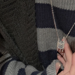 Detail of S925 sterling silver retro pouch pendant with floral engraving and bead tassels
