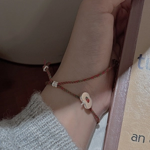 Bracelet tissé à la main avec breloque champignon en argent et perles sur un livre