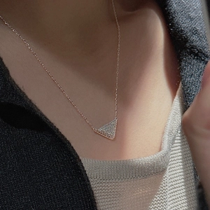 Close-up of sparkling triangle zircon pendant on a delicate rose gold choker necklace