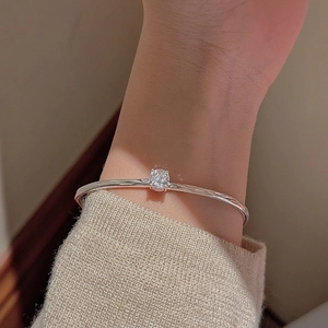 Detail of S925 silver wave texture bangle with sparkling round zircon on a model's wrist