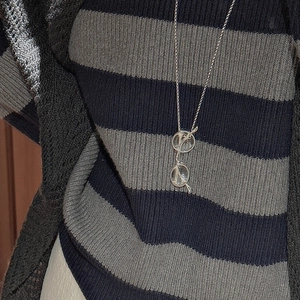 Collier minimaliste en argent S925 avec pendentif lunettes sur un pull à rayures