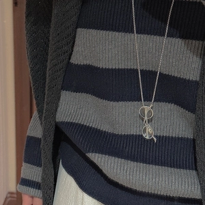 Collier avec pendentif lunettes vintage en argent S925 sur un pull à rayures