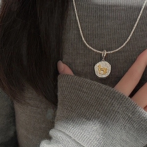 S925 sterling silver vintage two-tone horse coin pendant necklace on a grey sweater