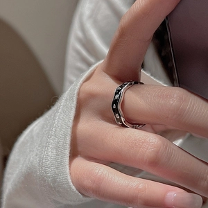 Macro detail of wave shaped S925 silver ring with black enamel and sparkling rhinestones