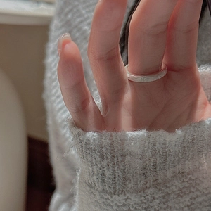 Macro shot of minimalist S925 sterling silver ring with brushed matte texture on hand