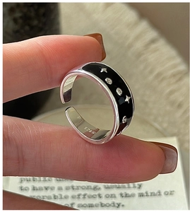 Macro view of S925 sterling silver ring with black enamel and star-embossed detail
