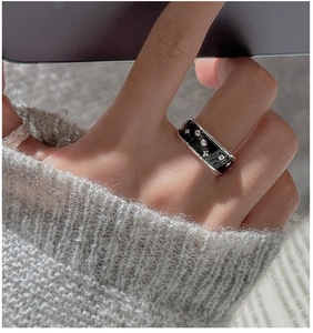 Close-up of S925 silver wide band ring with black enamel drip glaze and star detailing