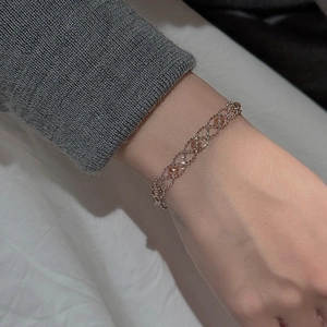 Detailed shot of rose gold lace bracelet with hollow diamond mesh on a knitted sleeve