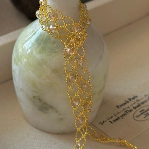 S925 silver lace woven necklace with gold beads and champagne crystals on a vase