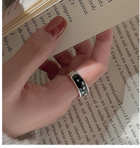 Macro view of S925 sterling silver star and moon ring with black enamel details