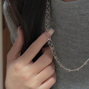 Detail view of S925 silver lace necklace with beads on a model wearing a grey sweater