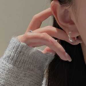 S925 sterling silver hoop earrings with organic twist design on an elegant model