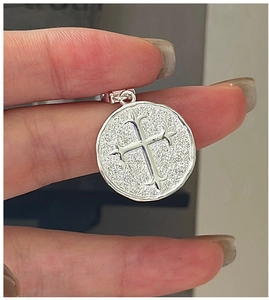 Macro du pendentif croix en argent S925 avec texture martelée vintage et fleur de lys