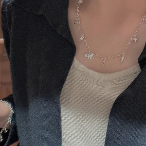 S925 sterling silver necklace and bracelet set with birdcage and bow charms on a model