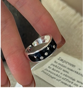 Macro shot of S925 sterling silver ring with black enamel star and zircon stones