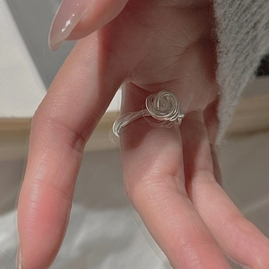 Detailed view of handcrafted silver knot ring with 3D rose bud wire wrap design