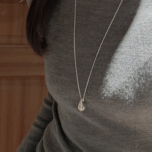Minimalist S925 sterling silver teardrop pendant necklace worn on a gray sweater