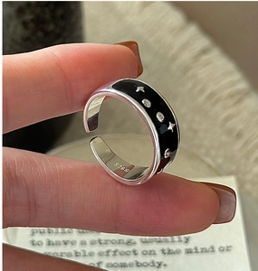 Detail of S925 sterling silver ring featuring black drip glaze and star patterns