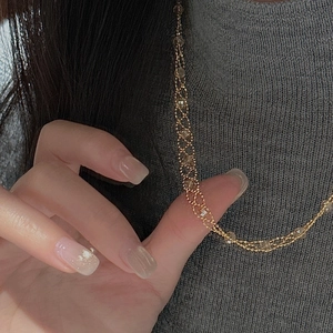 Close-up of golden multi-layer beaded necklace with elegant lace woven mesh design