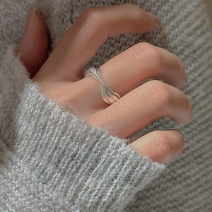 Detailed close-up of a minimalist S925 sterling silver twisted ring worn on a finger