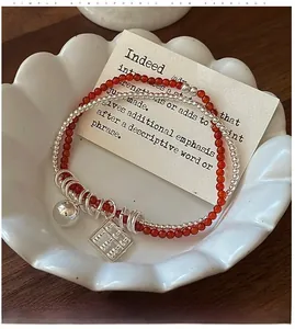 Detailed shot of double-layered silver abacus bracelet with red agate beads and shell tray