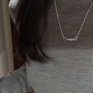 S925 sterling silver knot pendant necklace with fine chain on model wearing grey knitwear