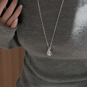 Minimalist s925 silver hollow teardrop pendant necklace on gray sweater background