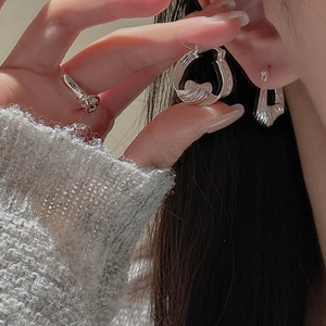 Detail of S925 sterling silver earrings with irregular lava texture and liquid metal design