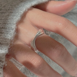 Macro detail of S925 sterling silver minimalist twisted ring on a warm knitted fabric