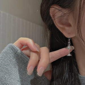 Chic S925 sterling silver lamp shaped drop earrings on model with sleek metallic finish