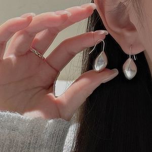 Détail de boucles d'oreilles gouttes en argent S925 avec finition miroir sur modèle