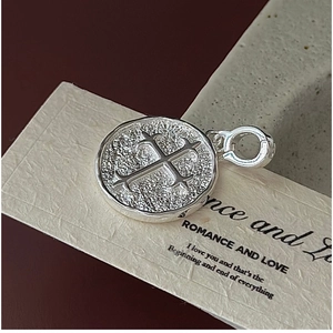 Gros plan du pendentif croix en argent S925 avec surface texturée martelée artisanale