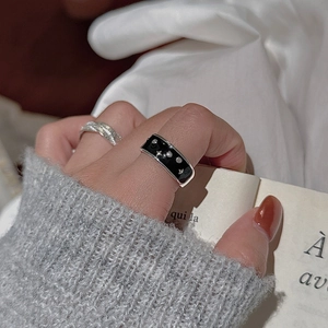 S925 sterling silver black enamel star ring with woven band on a woman's finger