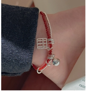 Close-up of S925 silver double-layered anklet with red beads and abacus charm
