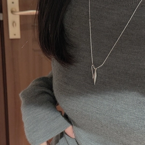 Close-up of minimalist S925 sterling silver drop pendant on a fine link chain necklace