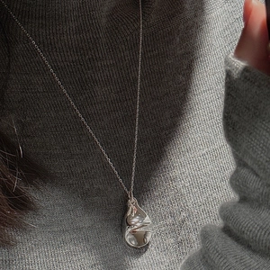 Minimalist S925 sterling silver teardrop pendant necklace on a grey knit sweater