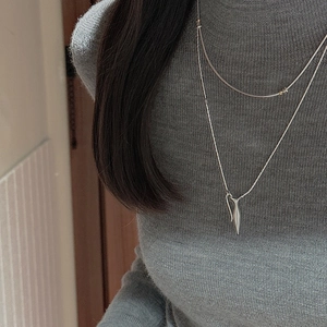 Close-up of double-layered S925 sterling silver necklace with a sleek spindle pendant