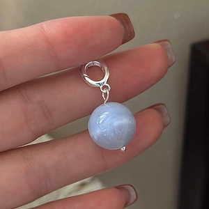 Minimalist S925 sterling silver round light blue agate pendant held in fingers