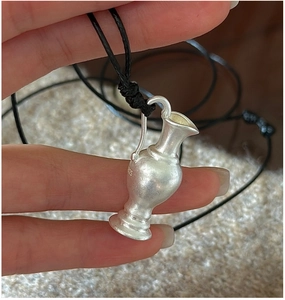 Close-up of S925 sterling silver vintage amphora pendant with a matte frosted finish