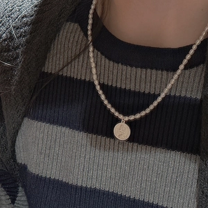 Vintage S925 silver pearl necklace with gold coin pendant shown on model neck
