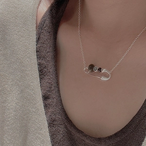 Détail du collier épingle en argent S925 avec perle lettre U porté par un mannequin