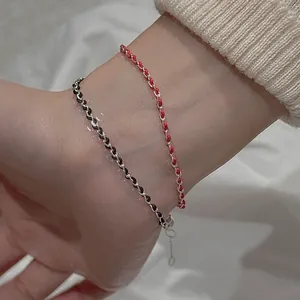 Detail of woven minimalist bracelet with adjustable silver chain in red and black
